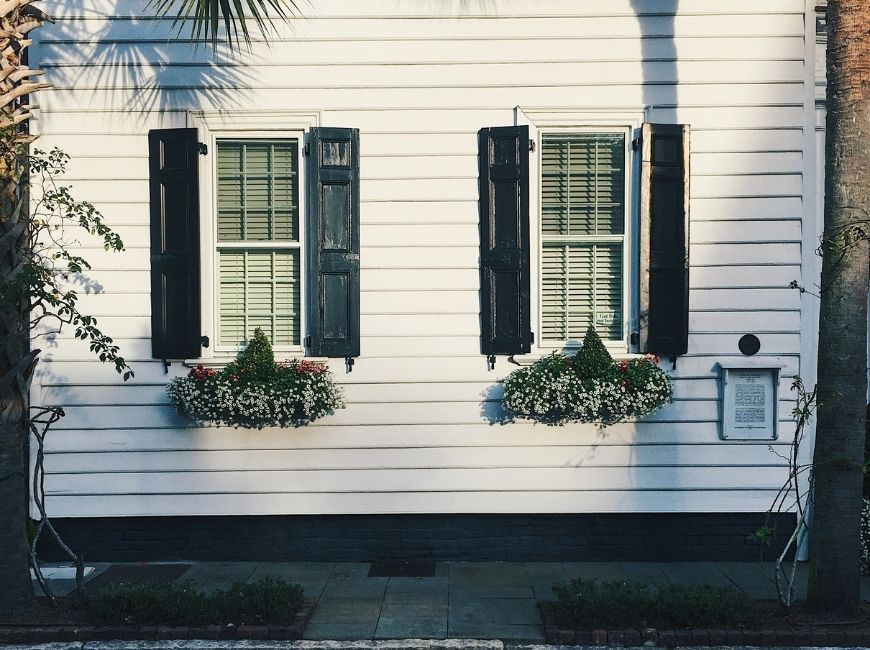 white house with black shutters and window boxes